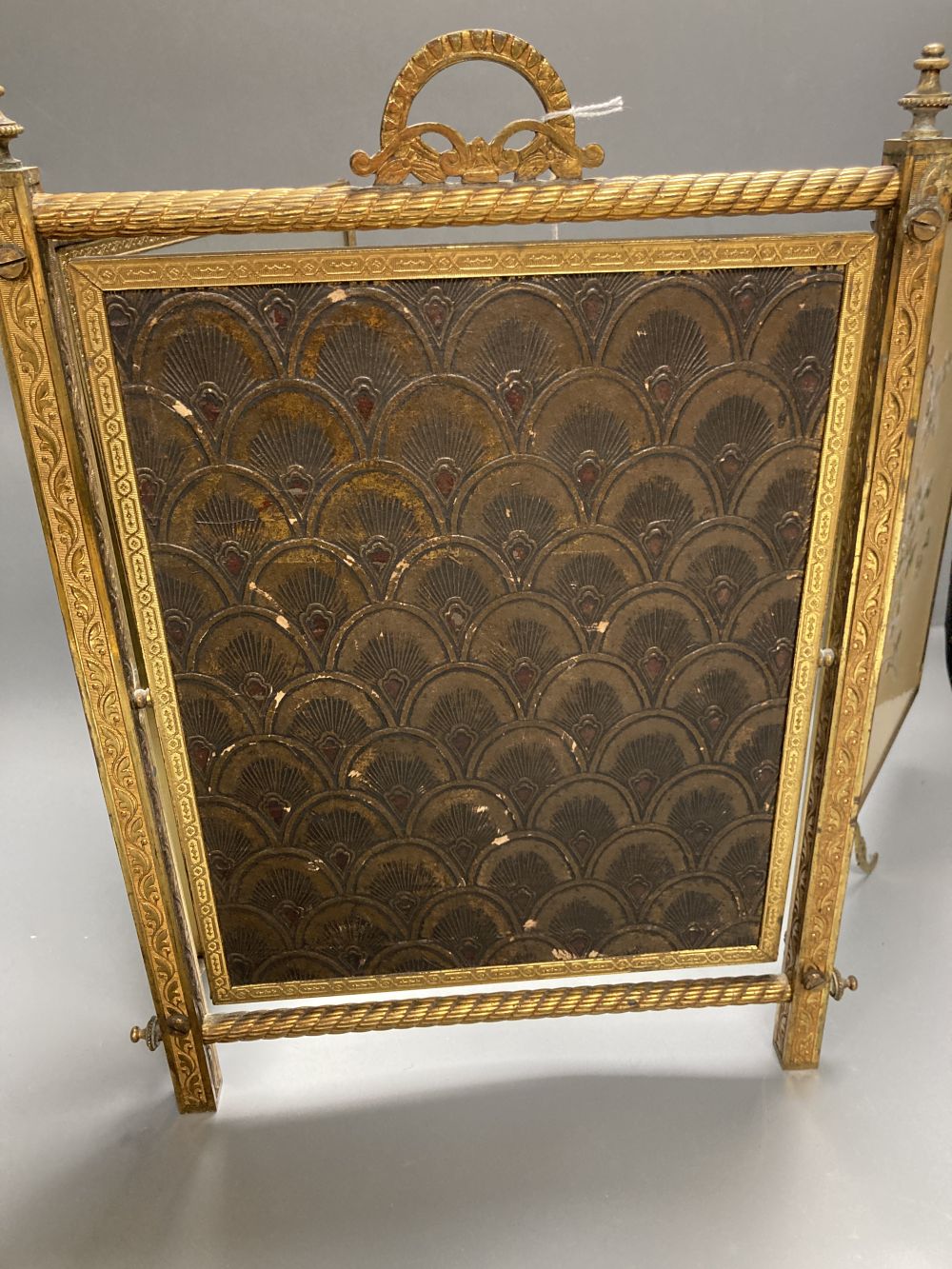 A gilt framed triptych mirror with faux ivory angelic panel and similar floral painted panel, height 41cm